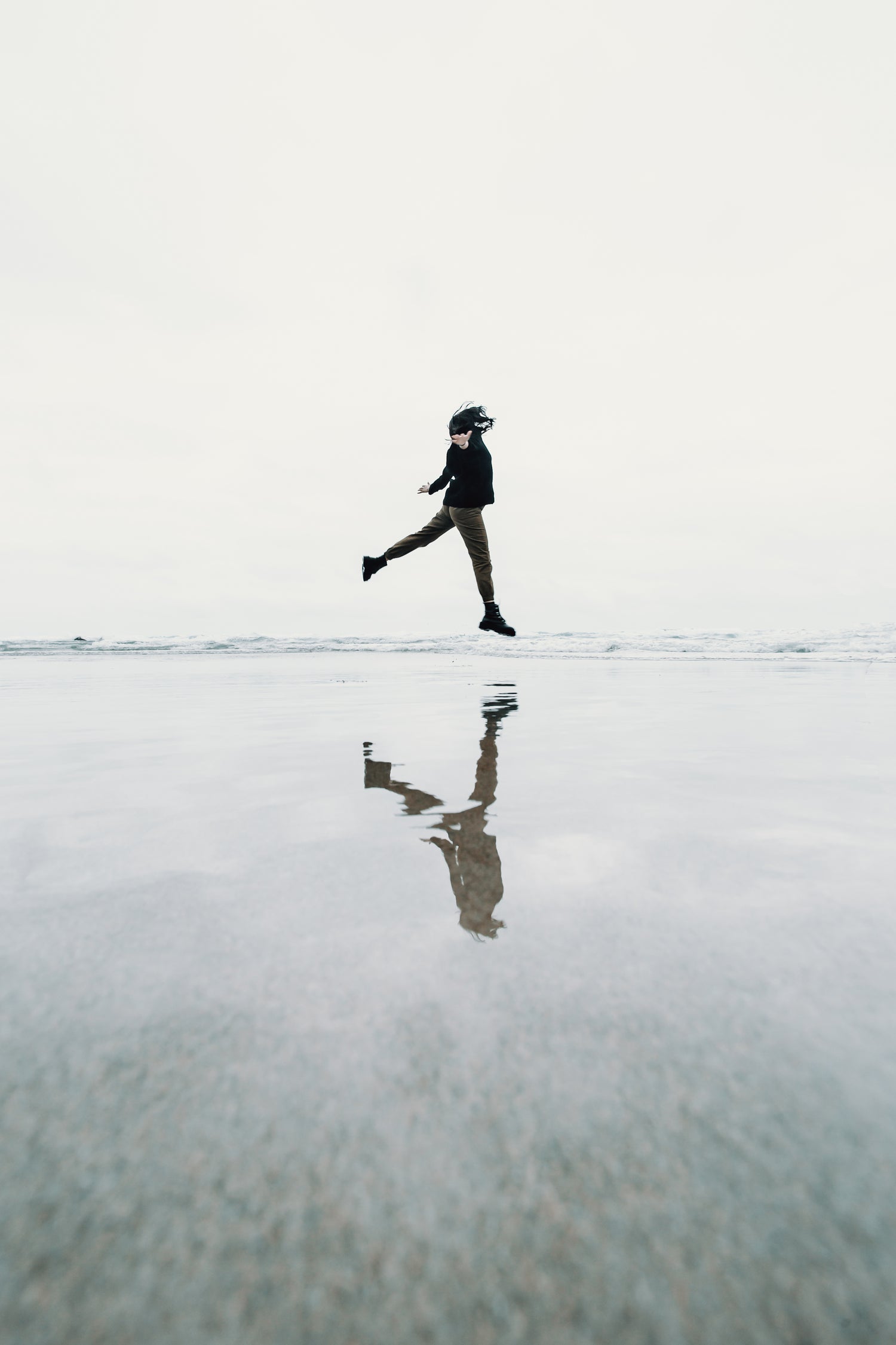 Person springt freudig am Strand in die Luft, ein Symbol für gesteigertes Wohlbefinden und Lebensfreude, ähnlich den positiven Effekten von Vital- und Heilpilzen auf die menschliche Gesundheit.